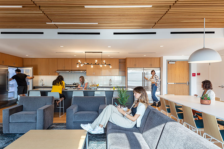 Students going about their business in a large open living room and kitchen area in Palm North
