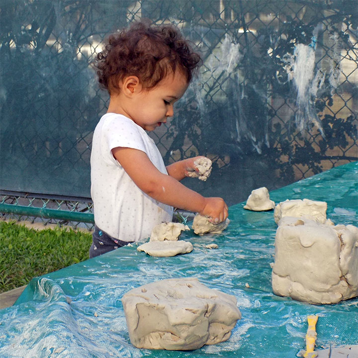 A young student playing with play dough